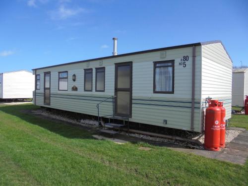 a train car is parked next to a fire hydrant at 8 Berth panel heated on Coral Beach (Willerby Westmorland) in Ingoldmells
