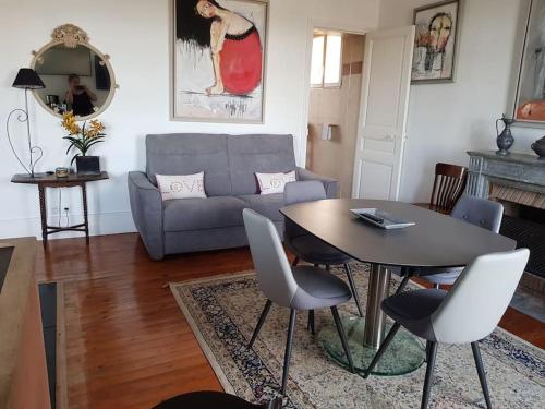 un salon avec une table et un canapé dans l'établissement Les Embruns - Le Balcon - 2eme Etage, à Deauville