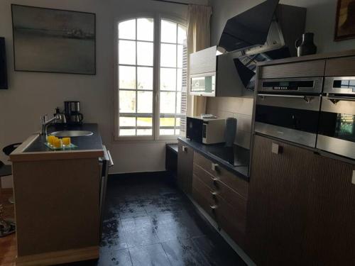 a large kitchen with a sink and a window at Les Embruns - Le Balcon - 2eme Etage in Deauville