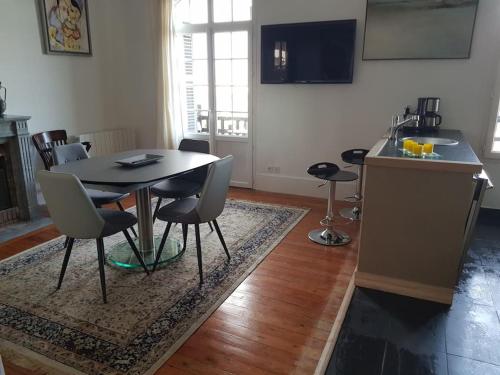 a kitchen and dining room with a table and chairs at Les Embruns - Le Balcon - 2eme Etage in Deauville
