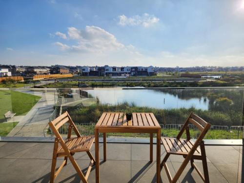 a table and two chairs on a balcony with a lake at Dream Family Retreat ! Escape Relax and Rejuvenate in Berwick