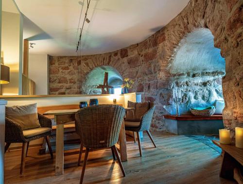 uma sala de jantar com uma parede de pedra e uma mesa e cadeiras em Muehlbastei-Bautzen-WellnessSuite em Bautzen
