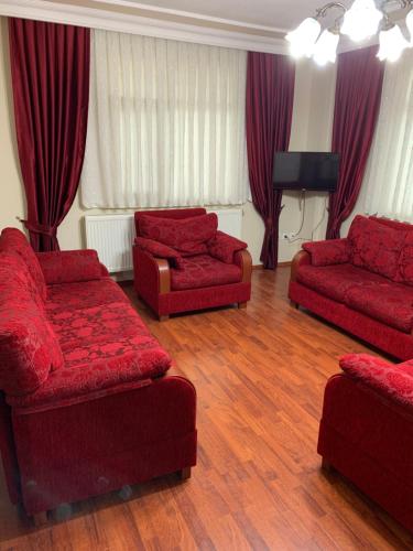 a living room with two red couches and a television at esa house in Kireçhane