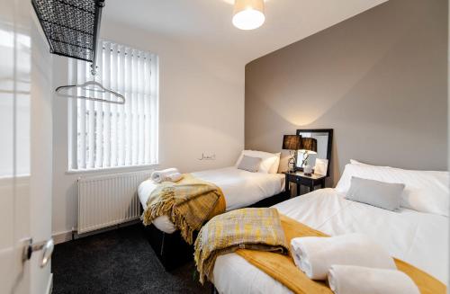 リバプールにあるLiverpool Harrow Road Sleeps 6- Infinity Apartmentのベッドルーム1室(ベッド2台、窓付)