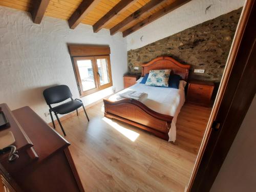 a bedroom with a bed and a chair in a room at Casa Montero in Gallegos de Argañán