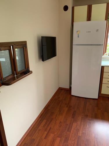 a kitchen with a refrigerator and a tv on the wall at esa house in Kireçhane
