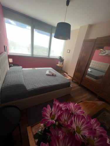 ein Schlafzimmer mit einem Bett und Blumen auf dem Boden in der Unterkunft La torre house in Civitavecchia