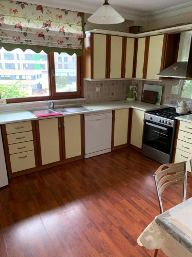 a kitchen with wooden floors and white counter tops at esa house in Kireçhane