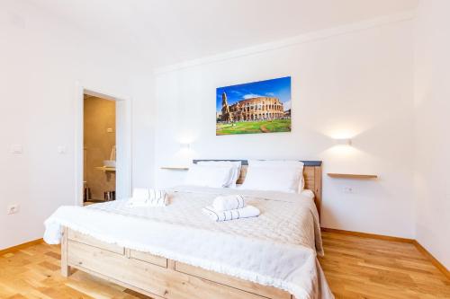 a bedroom with a large bed with white sheets at MP Luxury Holiday Home with swimming pool in Zadar