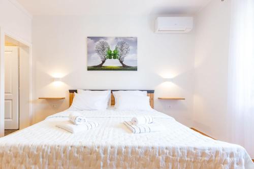 a bedroom with a white bed with two towels on it at MP Luxury Holiday Home with swimming pool in Zadar