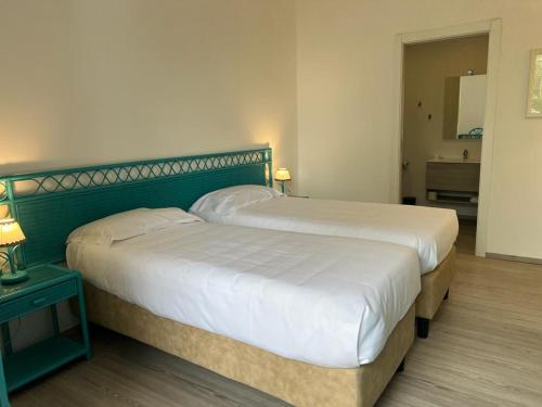 a bedroom with a large bed with a green headboard at Hotel Baia Delle Sirene in Taormina