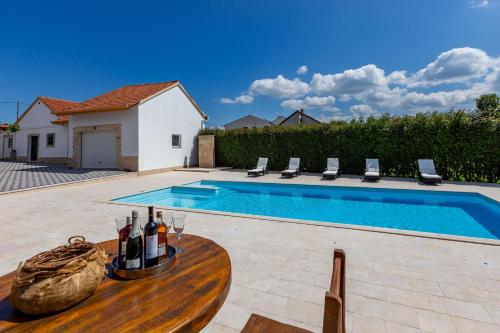 a swimming pool with a table with wine bottles on it at MP Luxury Holiday Home with swimming pool in Zadar