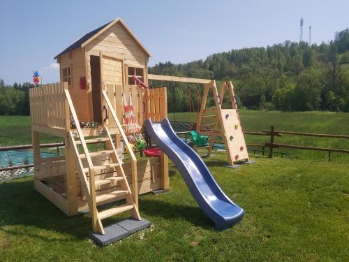 une aire de jeux avec un toboggan et une maison de jeux dans l'établissement Domek pod Hajdówką, à Jordanów