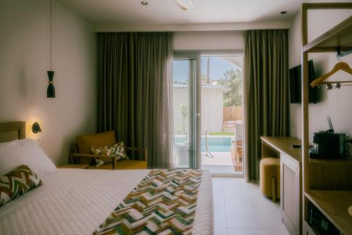 Habitación de hotel con cama y puerta corredera de cristal en Eterrano Seaside Retreat, en Parga