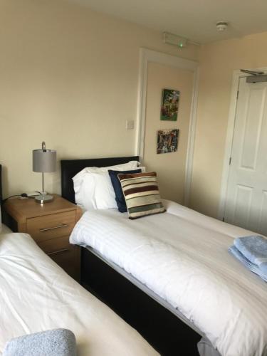 a bedroom with two beds and a table with a lamp at No 52 bed and breakfast in Helston