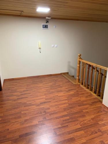 an empty room with a staircase and wooden floors at esa house in Kireçhane