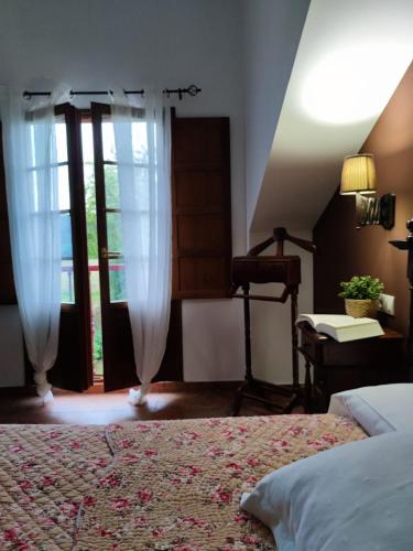 a bedroom with a bed with curtains and a window at Las Casonas de Avellaneda in Navia