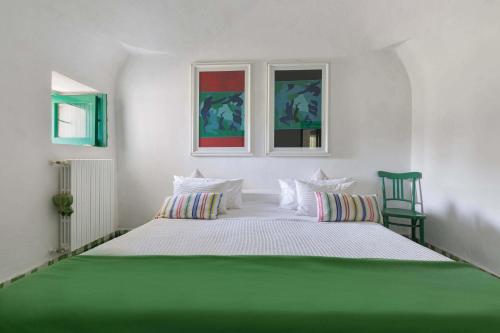 オストゥーニにあるTrulli Il Cappero by BarbarHouseの白い部屋の大型ベッド1台(窓2つ付)
