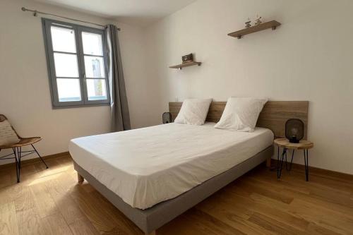 1 dormitorio con 1 cama con sábanas blancas y ventana en D24- T3-Les Hauts du Port-parking-clim-wifi-50m du port, en Bonifacio