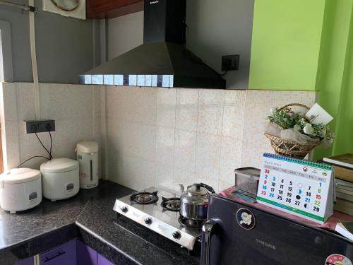 a kitchen with a stove and a counter top at The Loft Kohima 