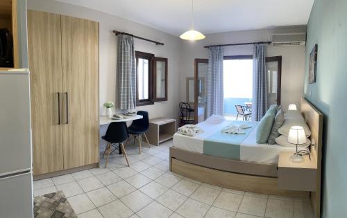セロカンポスにあるAsteras Apartmentsのベッドルーム1室(ベッド1台、テーブル、椅子付)