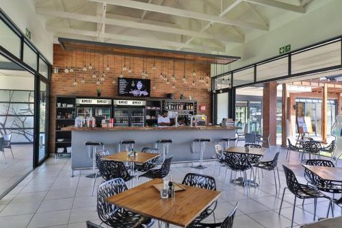 a restaurant with tables and chairs and a bar at Teasa Stays - Upliving Lifestyle nearby Fourways in Northriding