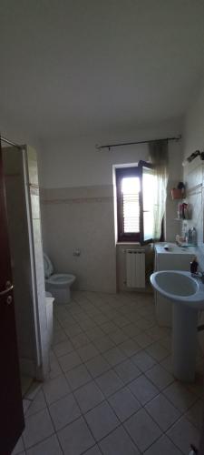Sezze的住宿－Casa tamara，一间带水槽和卫生间的浴室以及窗户。