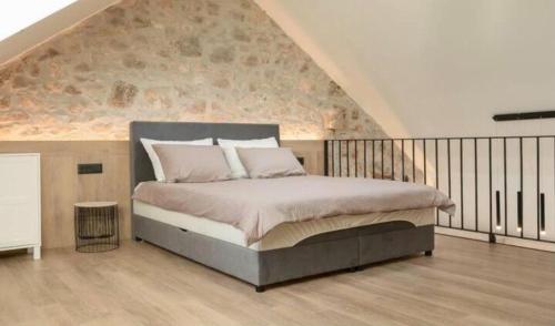 a bedroom with a bed with a stone wall at Apartments Sea Pearl in Makarska