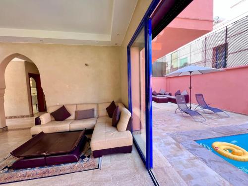 uma sala de estar com um sofá e uma piscina em Villa Traditional Family em Marrakech