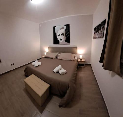Schlafzimmer mit einem Bett mit einem schwarz-weißen Bild an der Wand in der Unterkunft Casetta Dante 130 in Palermo