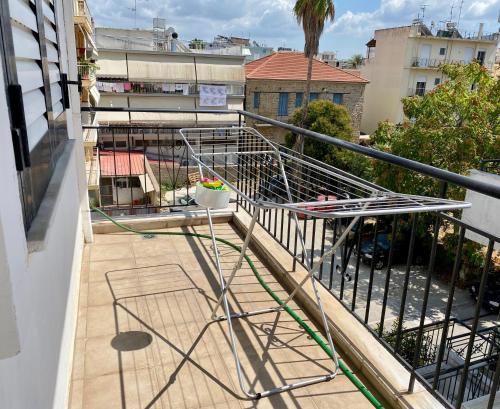 a balcony with a metal rack on the side of a building at Sunny Apartment Amaliada in Amaliás