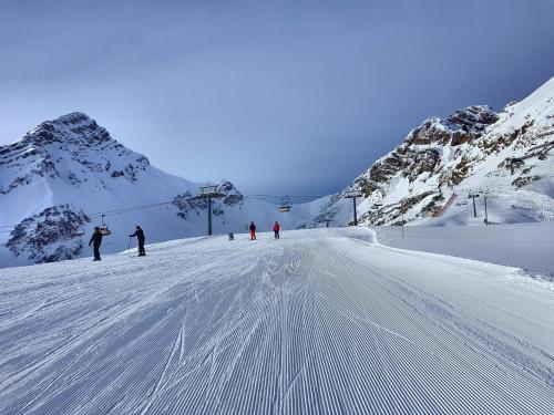 a group of people skiing down a snow covered mountain at Biotel Bertel Naturappartements in Brand