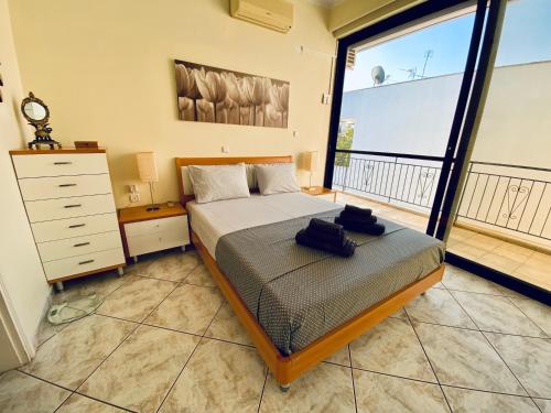 a bedroom with a bed and a large window at Sunny Apartment Amaliada in Amaliás