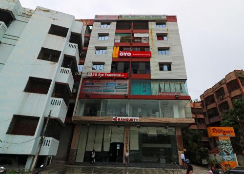 wysoki budynek apartamentowy z czerwoną i białą kolorystyką w obiekcie OYO Hotel Maruti Lodging w mieście Dum Dum