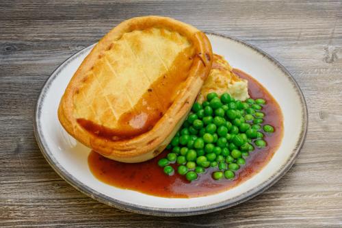 a plate of food with peas and a waffle at The Victoria Inn in Truro