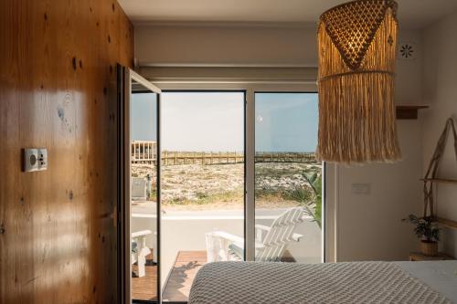 a bedroom with a bed and a view of the ocean at We Surf House in Figueira da Foz