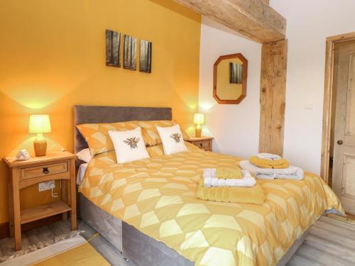 a bedroom with a large bed with yellow walls at Bee Happy Barn in Norwich