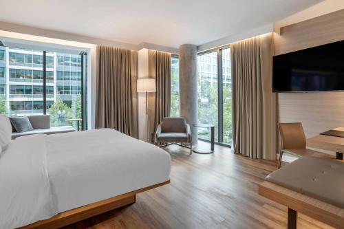 a bedroom with a white bed and a large window at AC Hotel by Marriott Washington DC Convention Center in Washington