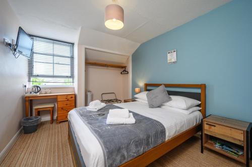 a bedroom with a bed with two towels on it at The Victoria Inn in Truro