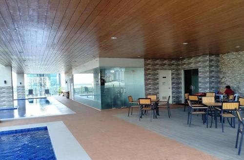 a lobby with tables and chairs and a swimming pool at Sunvida Tower Condominium across SM Cebu City in Cebu City