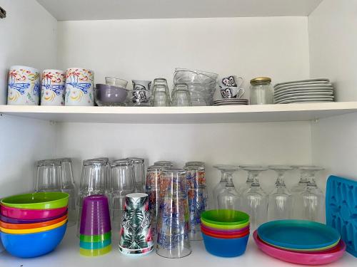 a shelf with many glass jars and plates on it at Sunny Apartment Amaliada in Amaliás