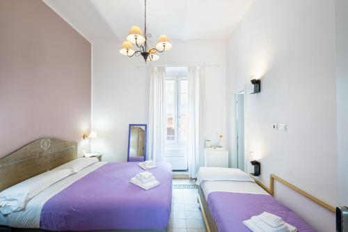 1 dormitorio con 2 camas y lámpara de araña en My Tiny Home Alchemy, en Roma