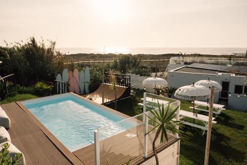 una piscina en la parte superior de una casa con el océano en We Surf House en Figueira da Foz