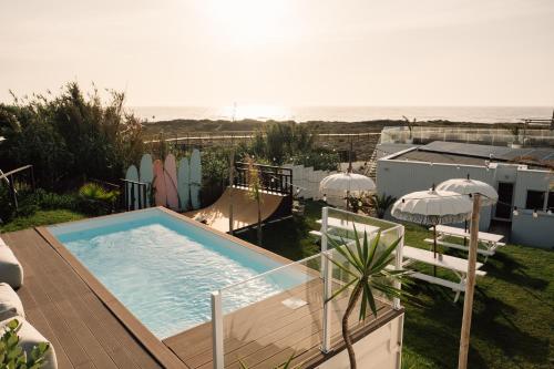 a swimming pool on top of a house with the ocean at We Surf House in Figueira da Foz