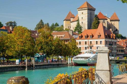 un bateau est amarré dans une rivière d'une ville dans l'établissement Très beau studio centre ville, au calme, à Annecy