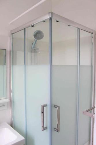 une douche avec une porte vitrée dans une salle de bain dans l'établissement Très beau studio centre ville, au calme, à Annecy