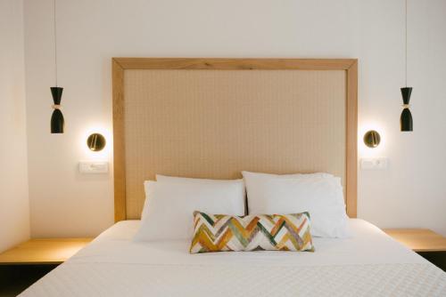 a bed with white sheets and a pillow on it at Eterrano Seaside Retreat in Parga