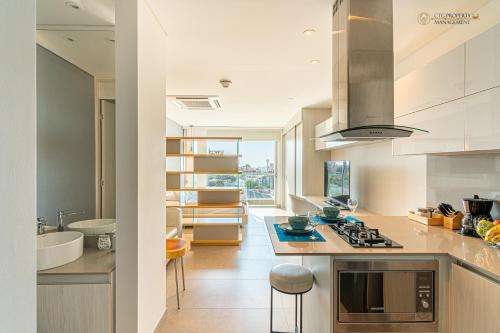 a kitchen with a sink and a stove top oven at Distrito 90 - Estudios y Apartamentos para vacaciones y viajes de negocio in Barranquilla