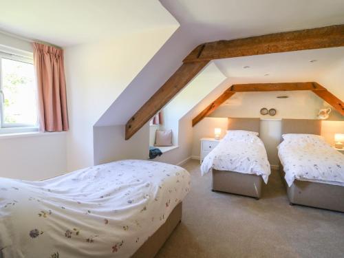 a bedroom with two beds in a attic at Cattle Tree Cottage in Cardigan