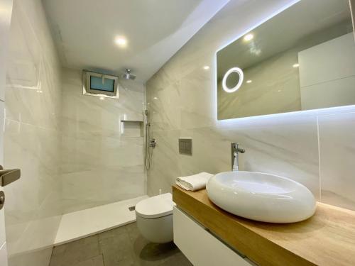 a white bathroom with a sink and a toilet at Sun golf house in Maspalomas